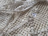 un gros plan sur un ouvrage au crochet blanc orné d'une fleur