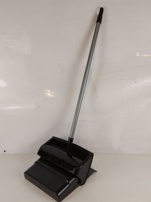 une pelle à poussière noire et un balai noir posés sur une surface blanche