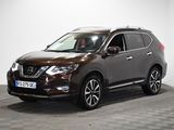 un SUV Nissan marron garé sur un sol à damier dans une pièce