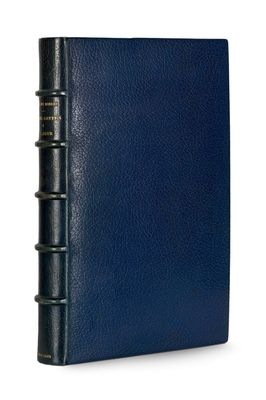 a blue leather bound book with three books on it