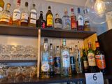 de nombreuses bouteilles et verres sur les étagères d'un bar