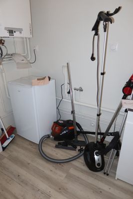 an image of a room with a washing machine and a vacuum