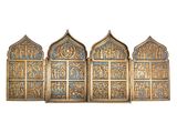 un ensemble de quatre décorations murales en métal doré et bleu sur fond blanc