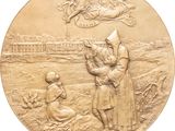 an image of a gold medal depicting a saint and a child