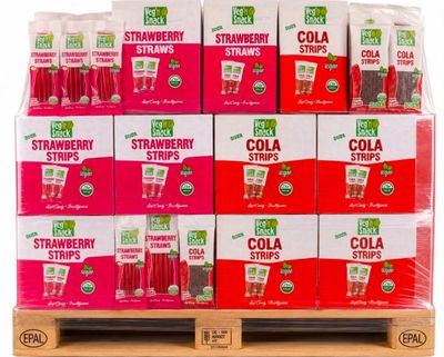 une pile de cartons contenant des pailles pour boissons au cola, posée sur une palette en bois