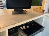 a computer monitor sitting on top of a counter in a kitchen