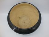 a black and tan bowl sitting on a white surface