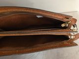 the inside of a brown purse with two zippers open