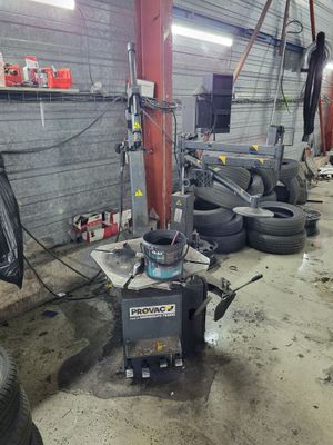 a machine that is sitting in a garage with some tires