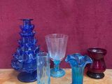 de nombreux vases en verre de différentes couleurs sur la table