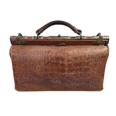 a brown leather bag with a handle on a white background