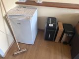 a white refrigerator and a black and white trash can in a room