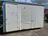 a white box sitting in the middle of a parking lot