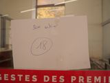une pancarte sur laquelle est inscrit un message manuscrit, placée devant une fenêtre