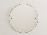 un miroir rond blanc accroché au mur, à côté d'un mur blanc
