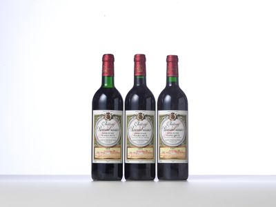 trois bouteilles de vin rouge posées sur une table