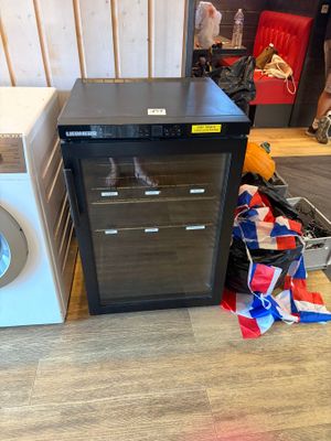 a small refrigerator and a washing machine in a room