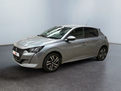 une voiture argentée garée dans une pièce blanche au sol noir