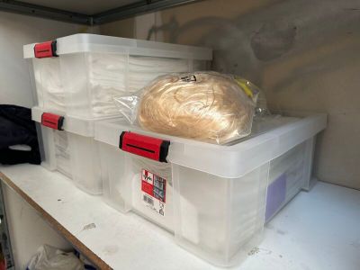 deux boîtes en plastique posées sur une étagère, contenant chacune une pelote de laine