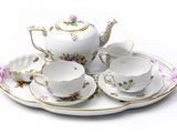 a tea set on a plate with a cup and saucer