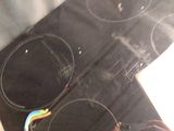 a person holding a toothbrush in front of an electric stove