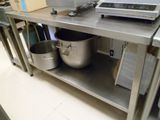 une étagère métallique sur laquelle sont posés une casserole et une poêle, dans une cuisine