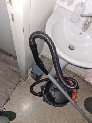 un aspirateur posé par terre à côté d'un évier