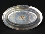 a silver plate on a black background with a diamond in the center