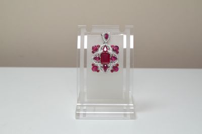 ruby and diamond earrings on display in clear acrylic holder