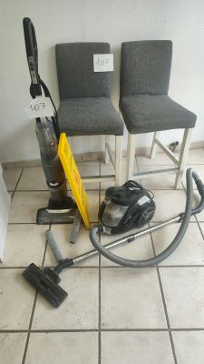 two chairs and a vacuum on the floor in a room
