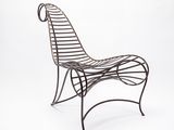 une chaise en fer avec un dossier et une assise incurvés, sur fond blanc