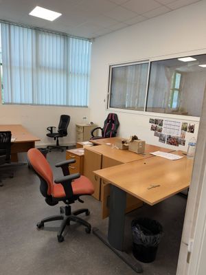 an image of an office with a desk and chairs