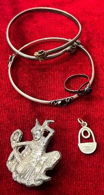 un collier, un bracelet et une bague posés sur un tissu rouge