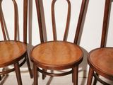 three wooden chairs sitting next to each other on top of a wooden floor