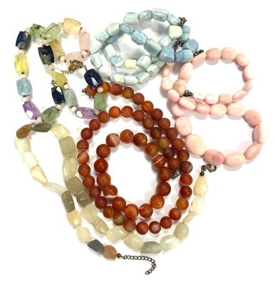 a lot of beads and bracelets on a white surface