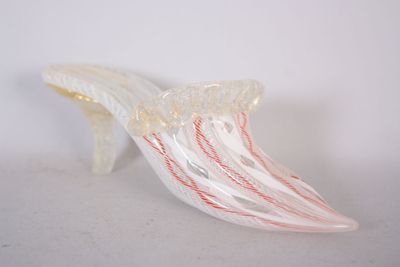 une chaussure en verre posée sur une surface blanche