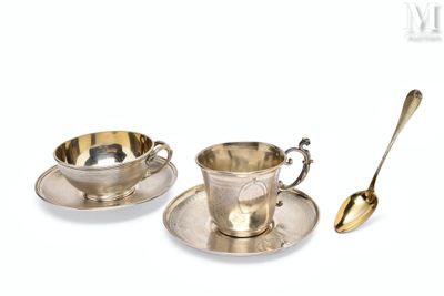 deux tasses et soucoupes en argent, accompagnées de cuillères, posées l’une à côté de l’autre