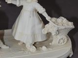 two figurines of a girl and a boy on a table
