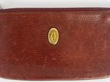 brown leather purse with a gold coin on top of it