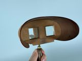a person holding a wooden object with two mirrors on it