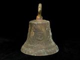 a bell that is sitting on a black surface