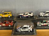 six model cars in a display case on a table
