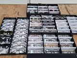 many pairs of glasses sitting in a box on the floor