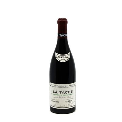 the bottle of wine is sitting on a white surface