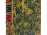 un vieux livre orné de fleurs jaunes, posé sur une surface blanche