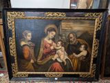 un vieux tableau représentant une famille avec un bébé dans une pièce