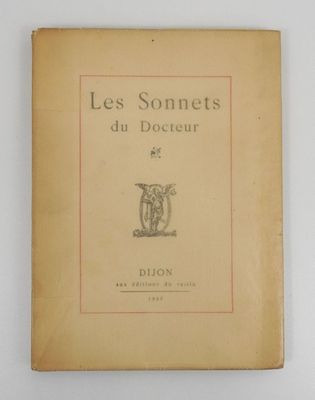 un vieux livre posé sur une table à côté d'un mur blanc