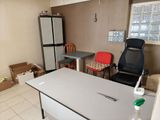 a room with a table, chair, refrigerator, and a window