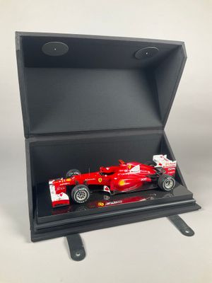 a red ferrari car in a black box on a white background