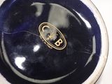 a blue and white bowl with a gold logo on it